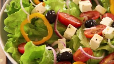Sebzeli yeşil salata ve masada beyaz peynir.