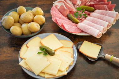 Masadaki bir raket için bir tabak şarküteri peyniri.