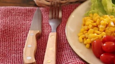 Bir tabak taze sebze ve masada jambon.