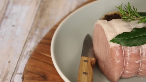 木の板の上の皿に生の豚のロースト — ストック動画