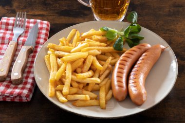 Kızarmış sosisli sandviçle bir tabakta bira ile birlikte.