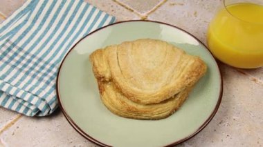 bir tabak portakal suyu ve meyveli börek.