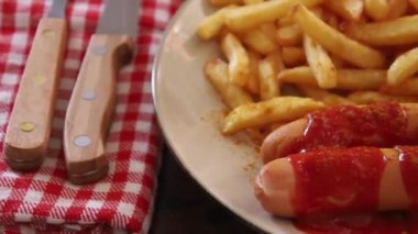 fast food. Patates kızartması, sosis, ketçap, beyaz tabakta. yakın plan