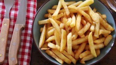 Bir tabak patates kızartması ve bir bardak biranın üst görüntüsü.