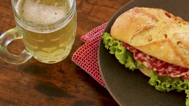 Sandwich Saucisse Sèche Dans Une Assiette Avec Une Bière — Video