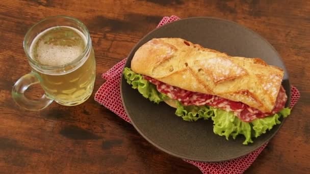 Trockenes Wurst Sandwich Auf Einem Teller Mit Bier — Stockvideo