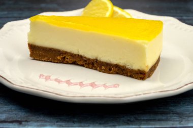 Gri arka planda bir tabakta limonlu cheesecake.