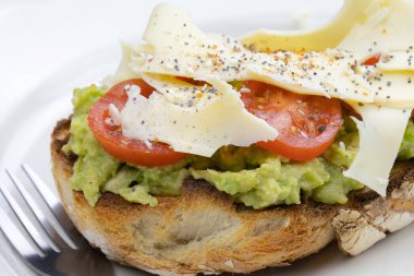 Peynirli, domatesli ve avokadolu lezzetli bir sandviç.