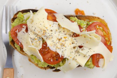 Peynirli, domatesli ve avokadolu lezzetli bir sandviç.