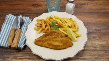 Masadaki tabakta patates kızartması olan pirzola.