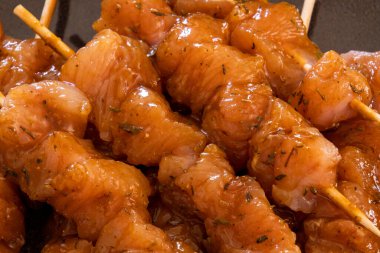 Bir tabakta birkaç çiğ tavuk şiş yakın