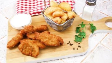Patates ve külçelerin üst görüntüsü bir tencere sosla panoda.
