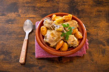 Tavuğun üstünde kayısı ve patates var.