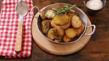 Tahta arka planda bir tabakta sardalya patatesi yakın plan.