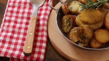 Tahta arka planda bir tabakta sardalya patatesi yakın plan.