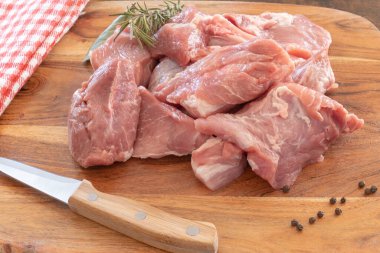 Tahtada izole edilmiş çiğ domuz eti parçaları.