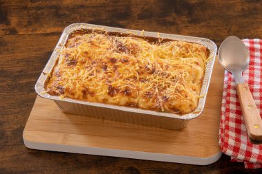 Tahta bir tabakta pişmiş lazanya manzarası.