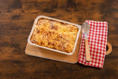 Tahta bir tabakta pişmiş lazanya manzarası.