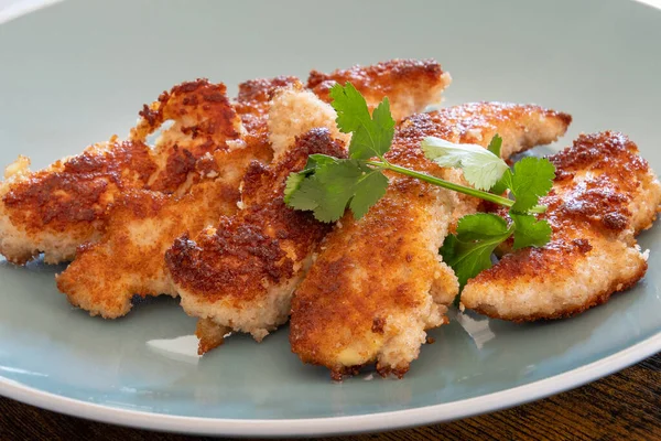 Tabakta ekmek kırıntıları olan kızarmış tavuk.