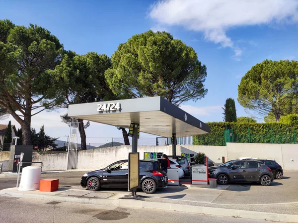 Benzin istasyonunda yakıt ikmali yapılan birkaç arabanın görüntüsü.