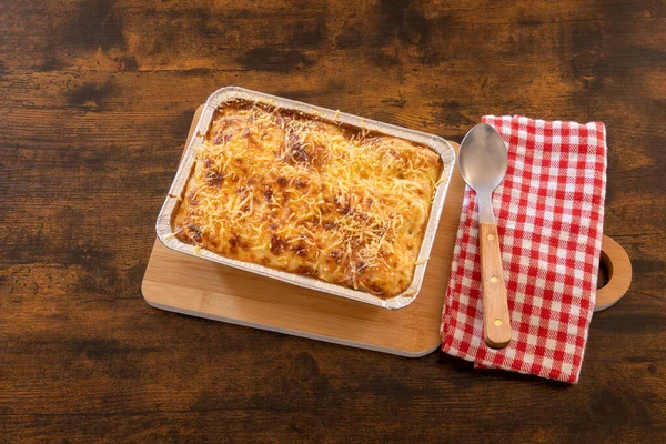 Tahta bir tabakta pişmiş lazanya manzarası.