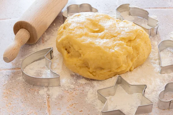 homemade shortcrust pastry on a board with flour and a rolling pin