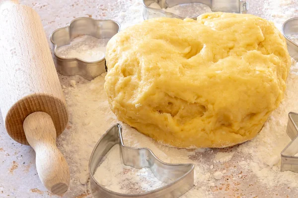 homemade shortcrust pastry on a board with flour and a rolling pin