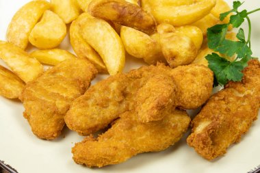 Fırında patates ve tavuklu nugget tabağı.
