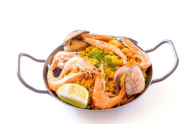 Beyaz arkaplanda izole edilmiş bir tabakta paella