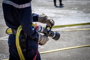 Tatbikat sırasında elinde yangın hortumu tutan kişi.