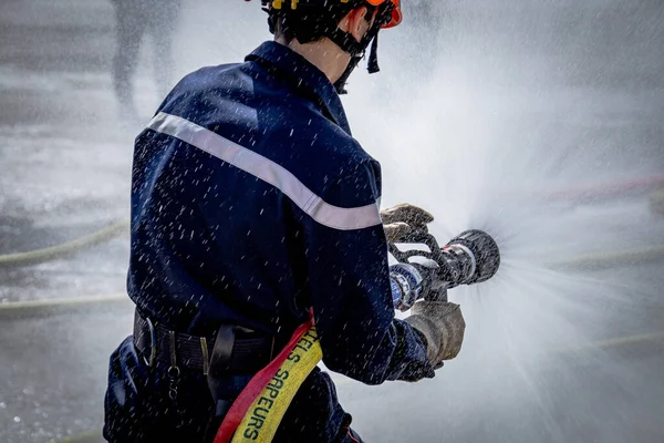 Pessoa Segurando Uma Mangueira Incêndio Durante Uma Broca — Fotografia de Stock