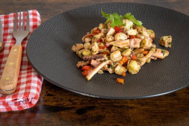 Tahta masadaki tabakta sarımsaklı kalamar salatası.