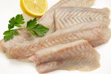 Çiğ balık filetosunu limonlu beyaz arka planda kapat