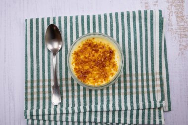 Bir kavanoz creme brulee Bir kaşık ile masada