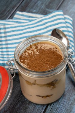 Gri arka planda bir kavanozdaki tiramisunun üst görünümü