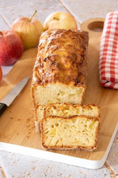 a cut apple cake on a wooden board