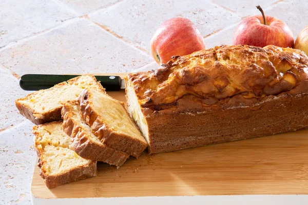 a cut apple cake on a wooden board