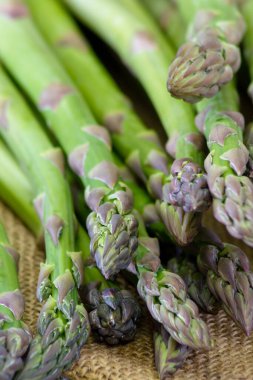Tahta arka planda taze yeşil kuşkonmaz.