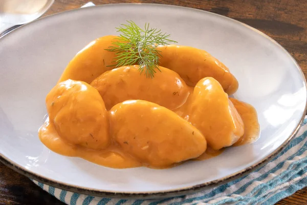 Masadaki beyaz tabakta domates soslu hamur köftesi.