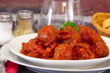 Masadaki tabakta domates soslu sığır eti köftesi.