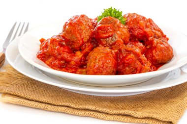 Çuval bezinde bir tabakta domates soslu etli börek.