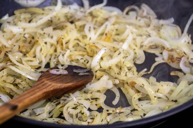 Kızartma tavasında ısıtılan otlu soğan yakın plan.