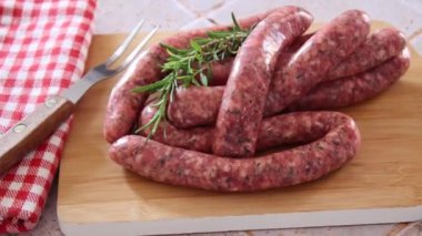 Tahtada ızgara yapmak için çiğ sosis.