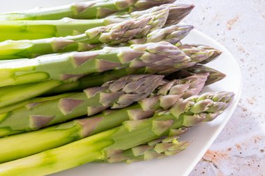 Birkaç çiğ yeşil kuşkonmazı kapatın.