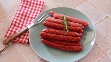 Masaya bir tabak çiğ merguez sosisi.