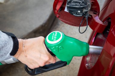 Yakıt pompasıyla arabaya yakıt dolduran kişi.