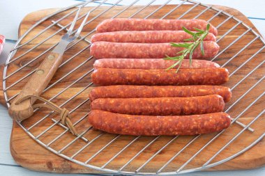 Izgarada çiğ merguez sosisi.
