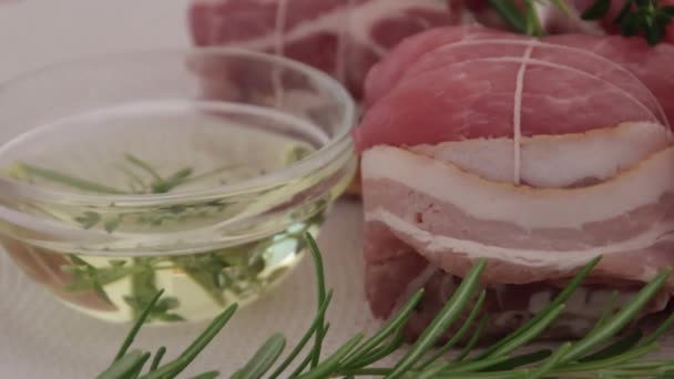 Daging Babi Mentah Gulung Dengan Minyak Dan Rosemary Atas Piring — Stok Video