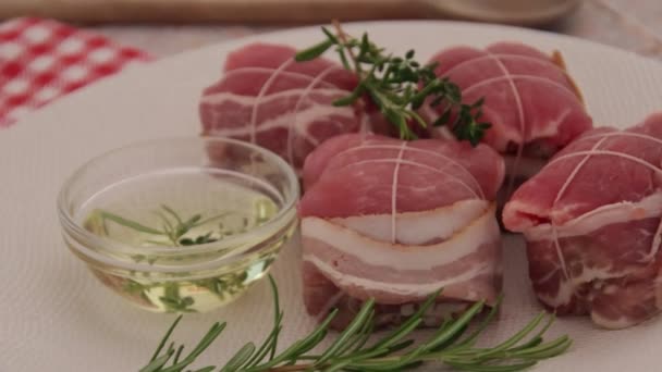 Daging Babi Mentah Gulung Dengan Minyak Dan Rosemary Atas Piring — Stok Video
