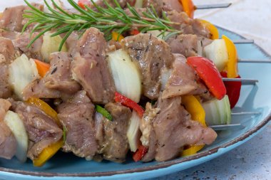 Tabakta marine edilmiş çiğ domuz şişi.